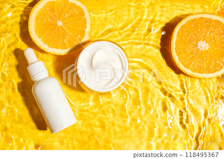 Cosmetic cream and serum bottle in yellow water background with orange citrus Cosmetic cream and serum bottle in yellow water background with orange citrus 118495367