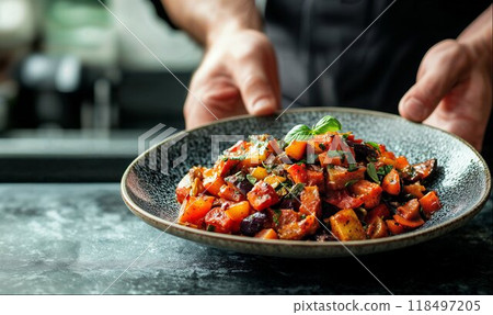 Chef holding a plate of ratatouille, kitchen background with copy space, hight detailed upscaled image 118497205
