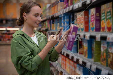 Woman scanning cereal box with smartphone in grocery aisle Woman scanning cereal box with smartphone in grocery aisle 118497599