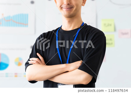 Smiling male businessman with his arms folded in front of a whiteboard 118497634