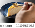 Hands eating a delicious mille crepe 118498198