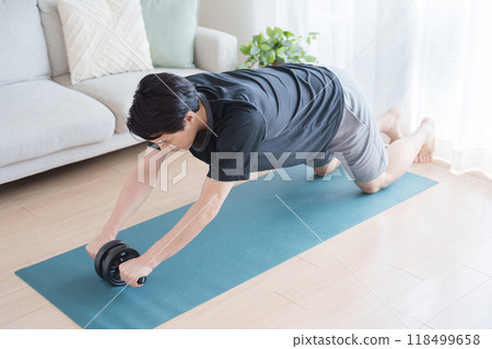 A man working out with an abdominal roller A man working out with an abdominal roller 118499658
