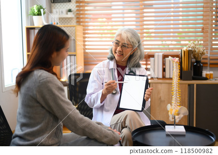 Mature female doctor showing medical test results on digital tablet to her patient. Healthcare services concept 118500982