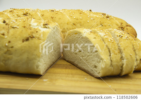 Wheat bread baked from flour at home. Sliced bread on wooden board against background. Food with NO GMO. Homemade bread with spice on it. Wheat bread baked from flour at home. Sliced bread on wooden board against background. Food with NO GMO. Homemade bread with spice on it. 118502606