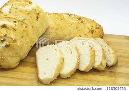 Wheat bread baked from flour at home. Sliced bread on wooden board against background. Food with NO GMO. Homemade bread with spice on it. Wheat bread baked from flour at home. Sliced bread on wooden board against background. Food with NO GMO. Homemade bread with spice on it. 118502733