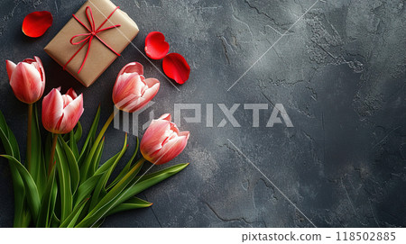 The bouquet is placed on a plain, gray background, possibly a concrete surface, which provides a stark contrast to the vibrant pink of the tulips. The bouquet is placed on a plain, gray background, possibly a concrete surface, which provides a stark contrast to the vibrant pink of the tulips. 118502885