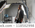 Professional photographer in modern studio with equipment setup and soft lighting 118502998
