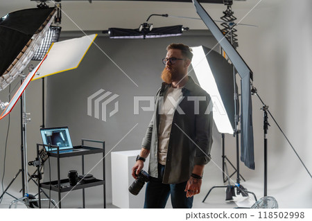 Professional photographer in modern studio with equipment setup and soft lighting Professional photographer in modern studio with equipment setup and soft lighting 118502998