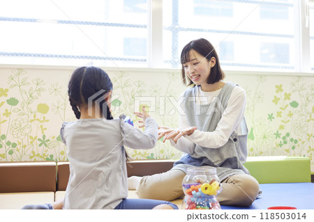 一名女保育員在幼兒園與孩子玩玩具 一名女保育員在幼兒園與孩子玩玩具 118503014