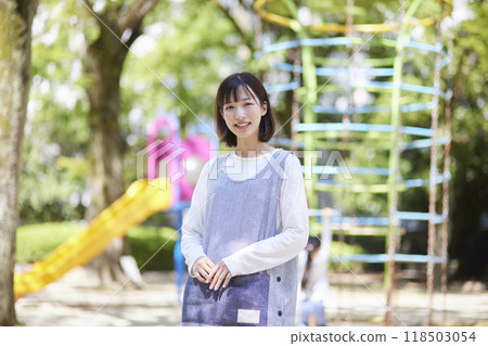 一張幼兒園女教師在幼兒園操場上微笑的肖像照。 一張幼兒園女教師在幼兒園操場上微笑的肖像照。 118503054