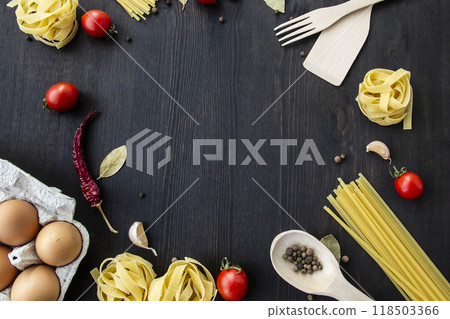 Cooking food background with free space for text. Composition with spaghetti, tomato, eggs, garlic, bay leaf over the wood background. Ingredients for cooking with copy space. Top view for the design Cooking food background with free space for text. Composition with spaghetti, tomato, eggs, garlic, bay leaf over the wood background. Ingredients for cooking with copy space. Top view for the design 118503366
