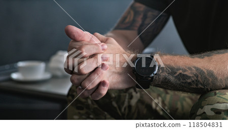 Close up of nervous military man clenching hands during therapy session 118504831