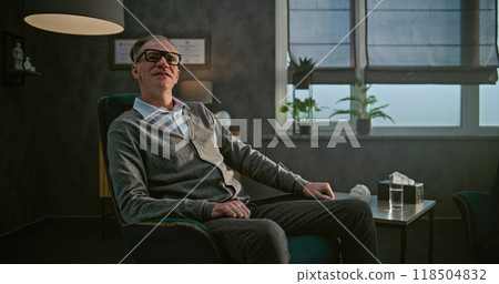 Portrait of a psychologist sitting in a chair in his office Portrait of a psychologist sitting in a chair in his office 118504832