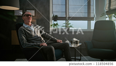 Portrait of a psychologist sitting in a chair in his office 118504856