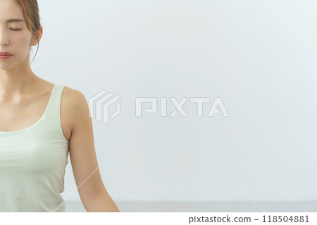 A young woman meditating during an online yoga salon broadcast A young woman meditating during an online yoga salon broadcast 118504881