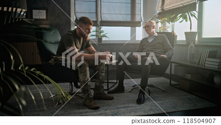 Depressed military man with PTSD talks to specialist on counseling session 118504907