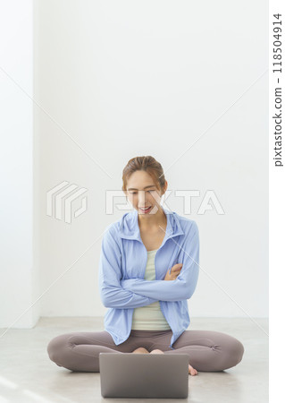 A young woman talking to a student at an online yoga salon 118504914