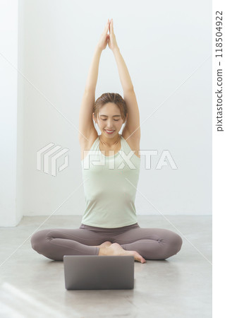 A young woman showing poses in an online yoga salon broadcast A young woman showing poses in an online yoga salon broadcast 118504922