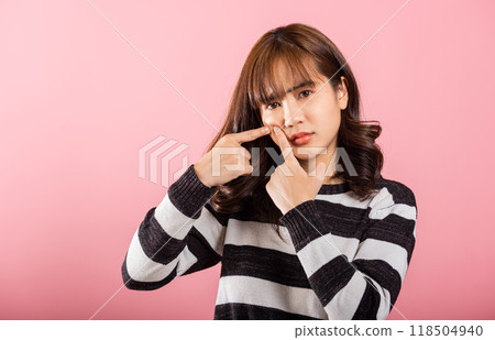 Portrait teenage Asian beautiful young woman having skin problems squeezing pimples acne on her face, studio shot on pink background, with copy space, Thai female acne, beauty care concept Portrait teenage Asian beautiful young woman having skin problems squeezing pimples acne on her face, studio shot on pink background, with copy space, Thai female acne, beauty care concept 118504940