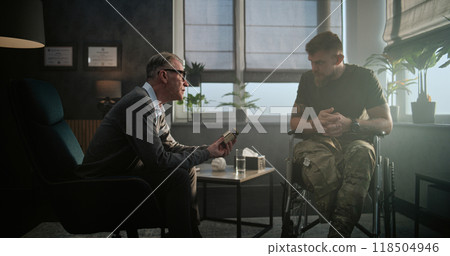 Senior psychotherapist gives sedative drugs or antidepressants to soldier in wheelchair 118504946