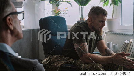 Military man with PTSD experiences negative emotions during therapy session 118504965