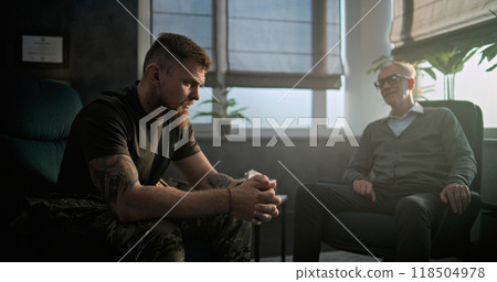 Depressed military man with PTSD talks to specialist on counseling session Depressed military man with PTSD talks to specialist on counseling session 118504978