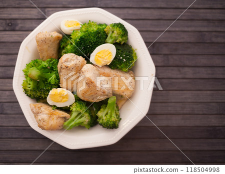 Healthy appetizer of chicken pieces with broccoli and quail eggs in bowl for healthy lunch 118504998