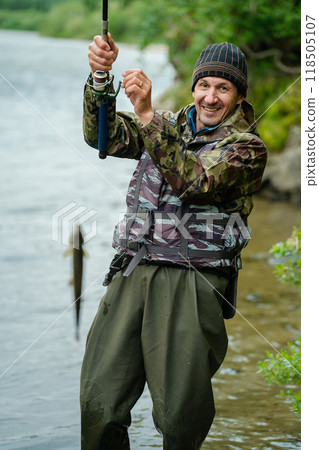 The fisherman caught a fish with a spinning rod 118505107