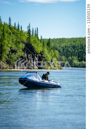 Fisherman on a boat on the river and forests 118505139