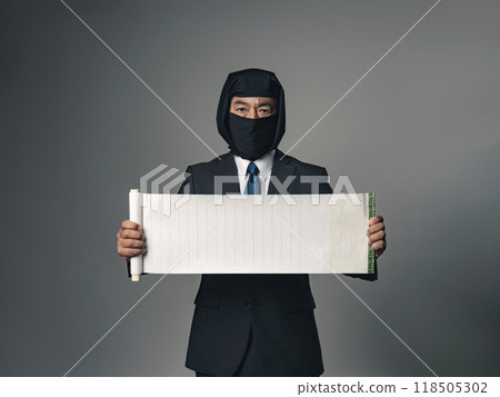 穿著西裝的忍者打開捲軸並向他展示。 118505302