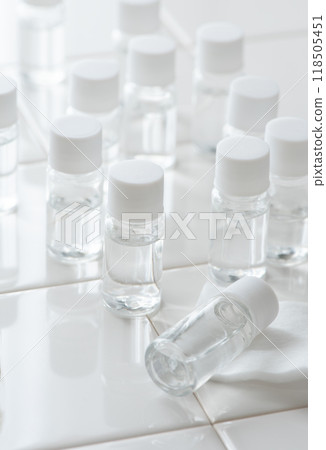 白色瓷磚上排列著許多小塑膠化妝品容器 118505451