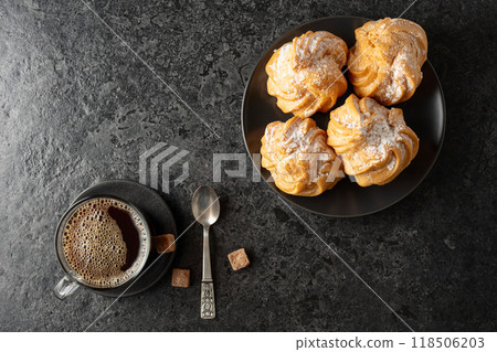 Cream cakes and black coffee on a black table. Cream cakes and black coffee on a black table. 118506203