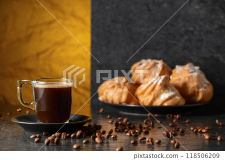 Black coffee in glass cup and coffee beans in motion on a black table. 118506209