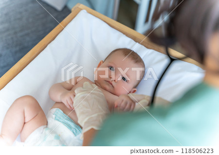 Infant baby at medical appointment doctor with stethoscope examining child 118506223