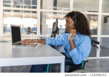 Disabled woman talking with clients over the phone from her office using headset Disabled woman talking with clients over the phone from her office using headset 118506253