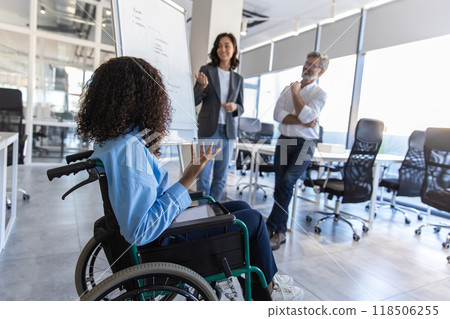 Executive woman with disability in wheelchair in office giving presentation on strategy 118506255