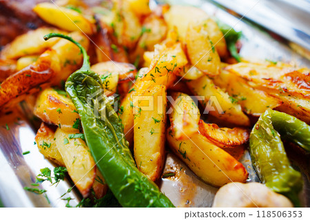 A dish with fried potatoes and green peppers. A dish with fried potatoes and green peppers. 118506353