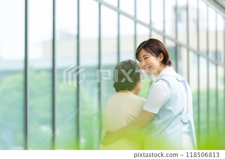Senior woman walking with a caregiver 118506813