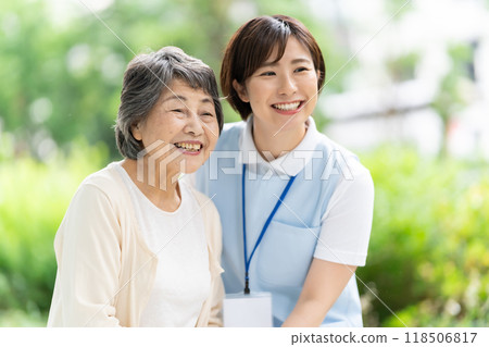 Senior woman walking with a caregiver 118506817