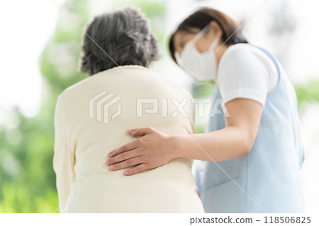 Senior woman walking with a caregiver 118506825