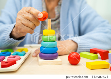 Alzheimer disease AD, Asian elderly woman patient suffering from dementia learn practical motor skills rehabilitation. Alzheimer disease AD, Asian elderly woman patient suffering from dementia learn practical motor skills rehabilitation. 118507871