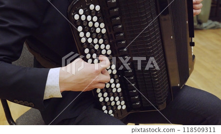 Musician playing black accordion with white keys close up 118509311