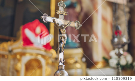 Silver crucifix standing in catholic church with blurred background 118509319