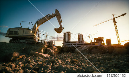 Morning at a construction site. Excavator in a pit against the construction site Morning at a construction site. Excavator in a pit against the construction site 118509462