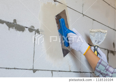 The concept of leveling the surface of a wall using a trowel. The concept of leveling the surface of a wall using a trowel. 118510104