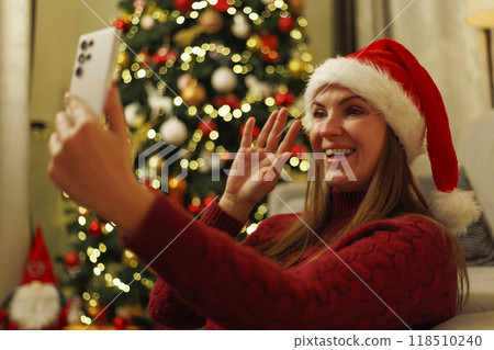 Woman in Santa hat making video call 118510240