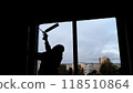 Construction worker is installing a window in a building using expanding foam insulation to seal it 118510864