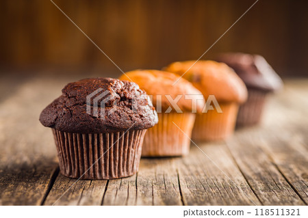 Sweet chocolate muffin cakes. Cupcakes on wooden table. 118511321