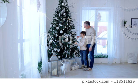 Father and son stand by Christmas tree faces beaming with joy celebrating warmth of family love. Caucasian family together by Christmas tree father and son share moment of happiness. 118511629