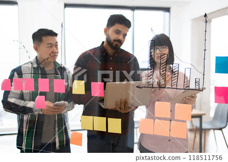 Business team brainstorming with sticky notes and charts Business team brainstorming with sticky notes and charts 118511756